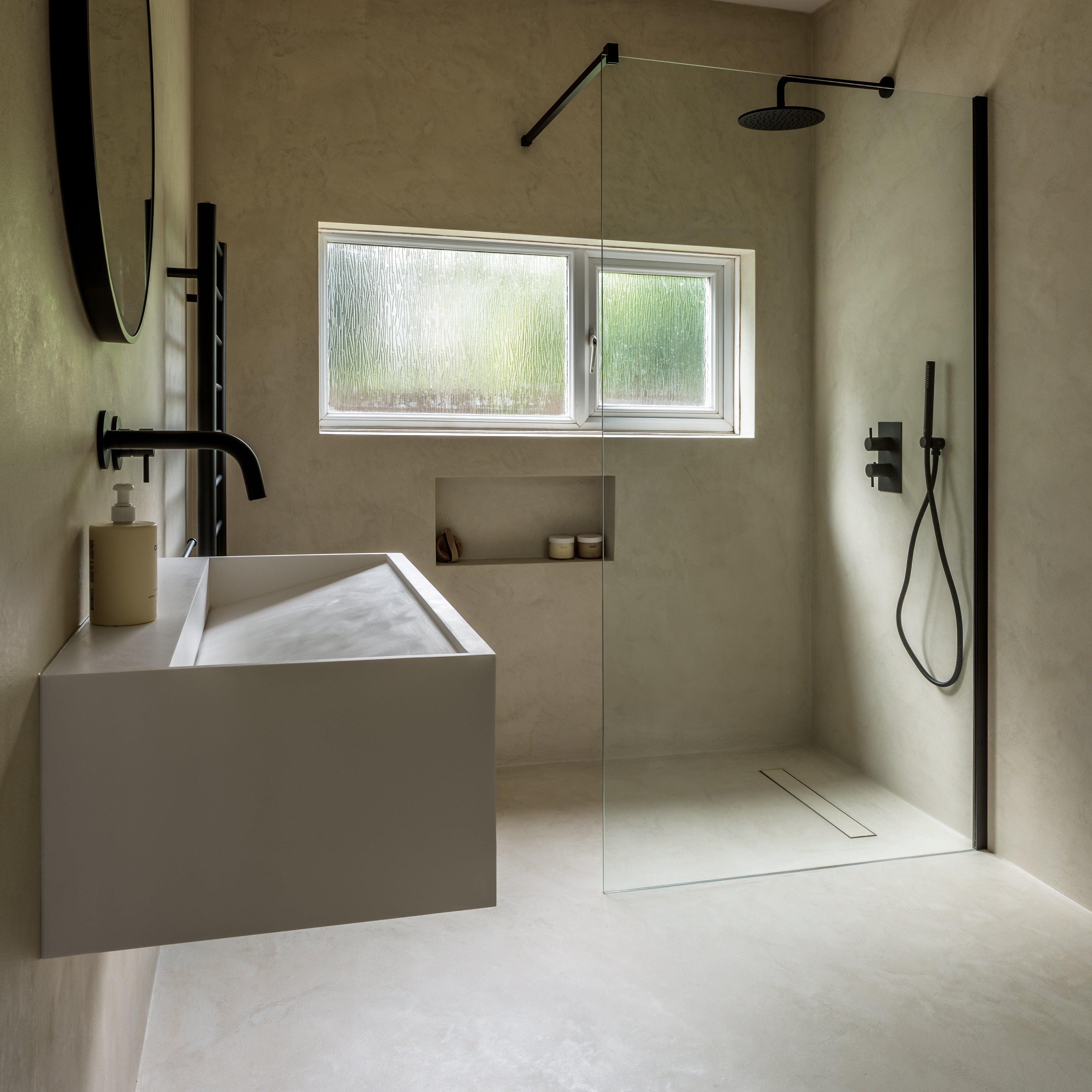 Modern bathroom with a sink, mirror, and shower area.